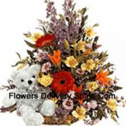 Mandje met verschillende bloemen en een schattige teddybeer