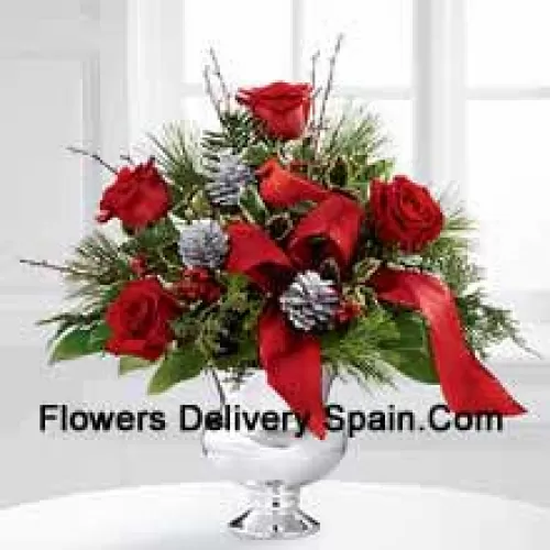 Altamente elegante y rebosante de tus deseos más alegres, este ramo será el regalo navideño perfecto. Las rosas rojas son vibrantes y brillantes, dispuestas con acebo variegado, varios verdes navideños, piñas plateadas y ramas, todo perfectamente acentuado con un cardenal falso y una cinta roja de diseñador. Presentado en un jarrón pedestal plateado, este ramo añadirá alegría y festividad a su temporada navideña con cada hermosa flor. (Tenga en cuenta que nos reservamos el derecho de sustituir cualquier producto por un producto adecuado de igual valor en caso de no disponibilidad de cierto producto)